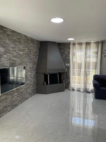 a living room with a fireplace and a stone wall at Your Seaside Escape in Oropos in Skala Oropou