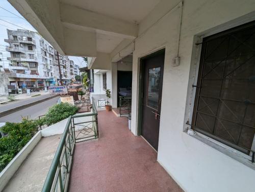 a balcony of a building with a door and a street at Swanky Sojourns Homestay in Kolhapur