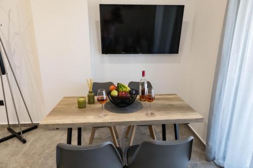 a table with two glasses of wine and a bowl of fruit at Aegeans Eye in Azolimnos