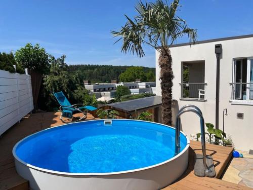 a bath tub on a patio with a palm tree at City Chillout Heidelberg, Apartment mit Sauna & Pool in Heidelberg
