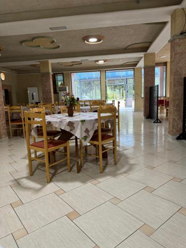 Hotel Marsil في Tepelenë: غرفة طعام مع طاولة وكراسي خشبية