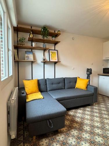 - un salon avec un canapé bleu et des oreillers jaunes dans l'établissement La Maisonnette, à Hulluch