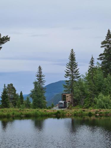 un camión estacionado frente a una casa junto a un lago en Vidsyn Midjås, en Vistad