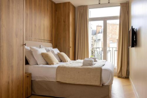 a bedroom with a bed with a large window at Luxurious Home in Triangle d'Or Eiffel Tower View in Paris