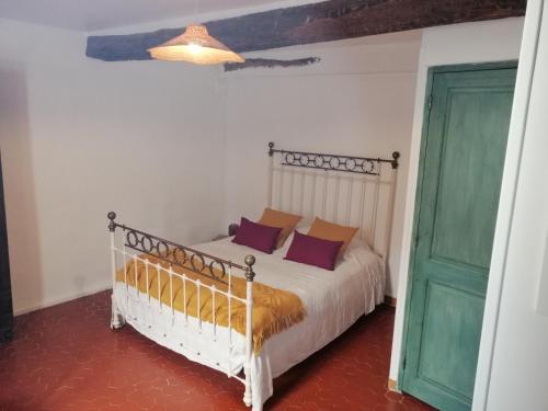 een slaapkamer met een bed en een groene deur bij La retapée in Quinson