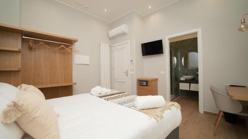 1 dormitorio con cama, escritorio y lavamanos en Manere Suites, en Palermo