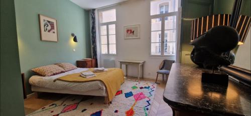 - une chambre avec un lit, une table et une fenêtre dans l'établissement Grand appartement Cours Mirabeau, à Aix-en-Provence