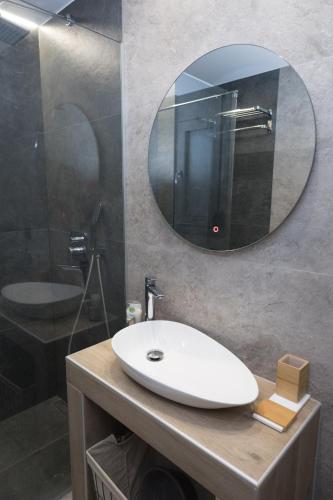 a bathroom with a white sink and a mirror at Aegeans Eye in Azolimnos