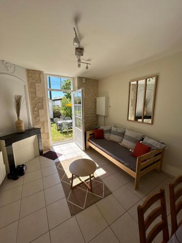 un salon avec un lit et une table dans l'établissement Le Domaine des Aguins, à Saujon