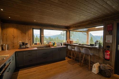 a kitchen with a counter with stools in it at Vidsyn Midjås in Vistad