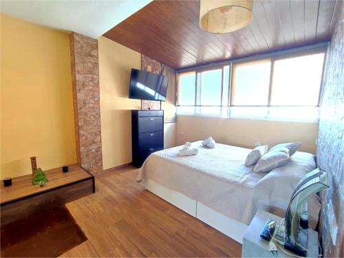 um quarto com uma cama e uma televisão em Ducal 9 Manga Norte em La Manga del Mar Menor