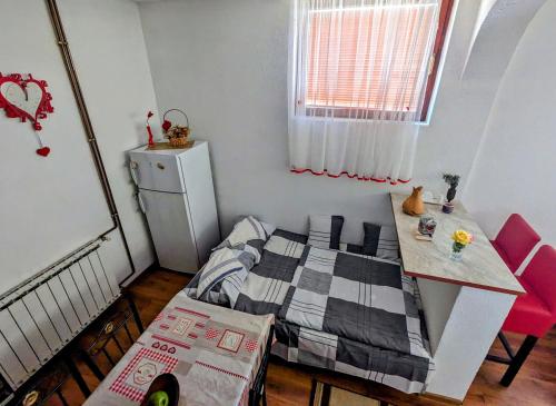 Dormitorio pequeño con cama y mesa en Apartment LAMI - Kalibunar, Travnik, en Travnik