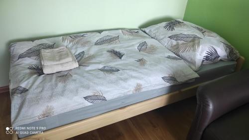 a bed in a room with a bed frame with pillows at Apartmán Sofia in Levice