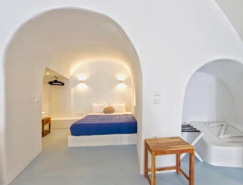 a bedroom with a bed in a white room at Karpimo Scenery in Firostefani