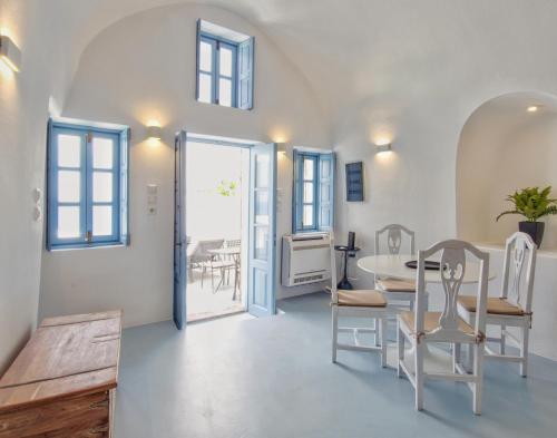 a living room with a table and chairs and a door at Karpimo Scenery in Firostefani