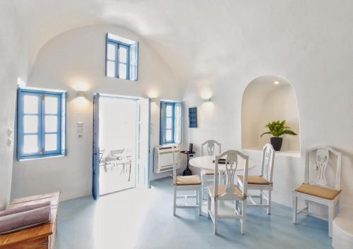 a room with a table and chairs and a door at Karpimo Scenery in Firostefani
