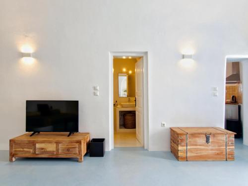 a living room with a flat screen tv and a coffee table at Karpimo Scenery in Firostefani