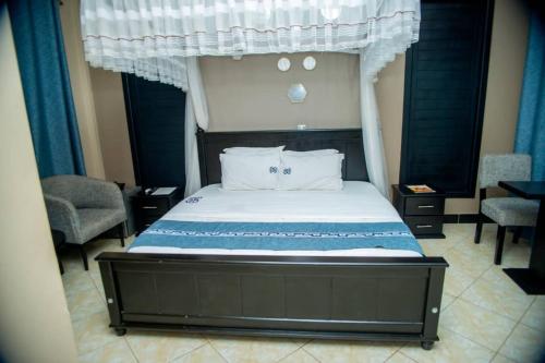 a bedroom with a bed with a canopy at Grady Hotel in Bulindo