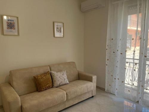 a brown couch in a living room with a window at Don Pippinu Home - Casa vacanze in Rosolini