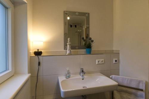 bagno con lavandino e specchio di Ferienhaus Strandmuschel am Ostseestrand Zierow a Zierow