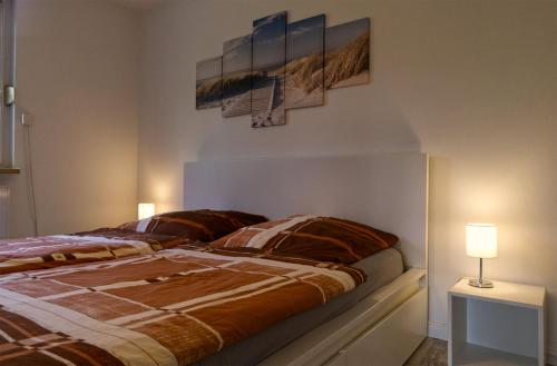a bedroom with a bed with two paintings on the wall at Ferienhaus Strandmuschel am Ostseestrand Zierow in Zierow