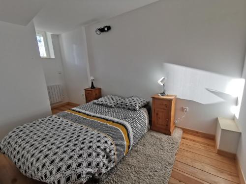 a bedroom with a bed with a black and white comforter at Le gîte de Melly in Bélesta