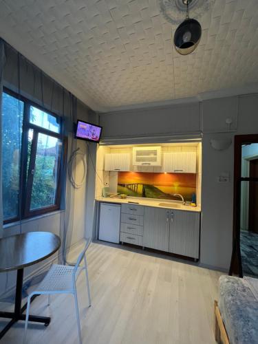 a kitchen with a table and a tv on the ceiling at Erkal Pension in Antalya