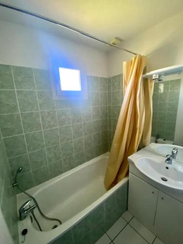 une salle de bain avec un lavabo et une baignoire et un lavabo dans l'établissement T2 Résidence Sun Hols les Rives du Lac piscine, jardin, à Saint-Saturnin-lès-Avignon