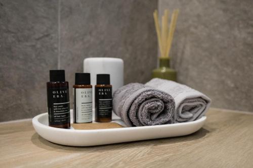 a tray with three bottles of essential oils and towels at Aegeans Eye in Azolimnos