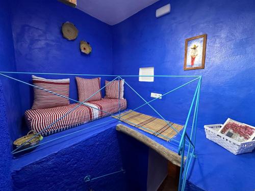 a blue room with a couch and a blue wall at DAR MUKTAB in Chefchaouene