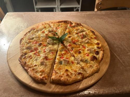 a pizza on a wooden plate on a table at Koukounari Agistri in Skala