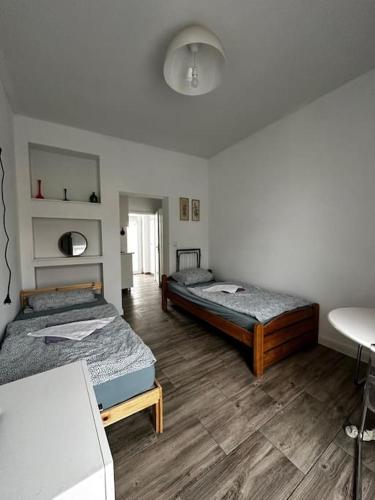 two beds in a room with wooden floors at Nice flat in Berlin 10 in Berlin