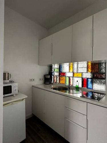 a kitchen with white cabinets and a microwave at Nice flat in Berlin 10 in Berlin
