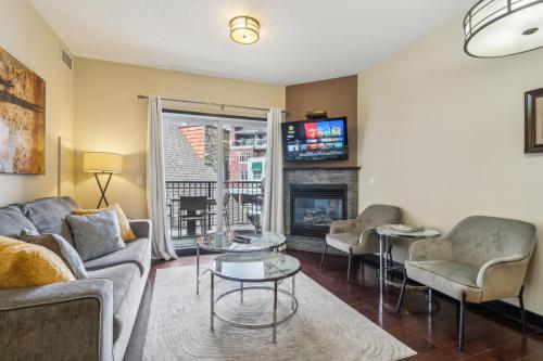 a living room with a couch and chairs and a fireplace at Cozy One Bedroom Condo with Indoor Pool and HotTub in Canmore