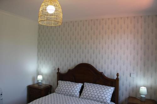 a bedroom with a bed and a pendant light at As Casinhas de Santo Ovidio in Fafe