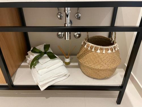 a shelf with towels and a basket on it at Magnólia 75 in Leça da Palmeira