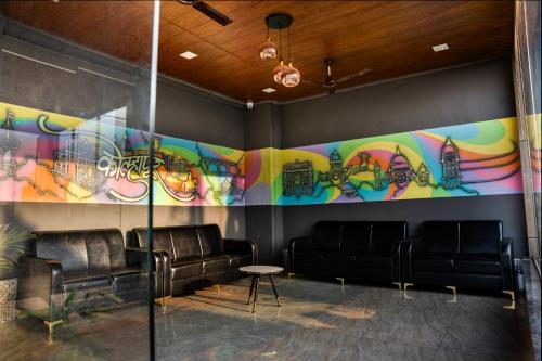 a room with couches and a graffiti covered wall at Hotel Happy Stay Kolhapur 2 km from kolhapur airport in Kolhapur
