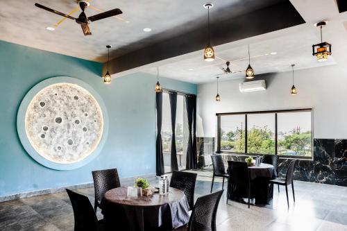 a dining room with tables and chairs and blue walls at Hotel Happy Stay Kolhapur 2 km from kolhapur airport in Kolhapur