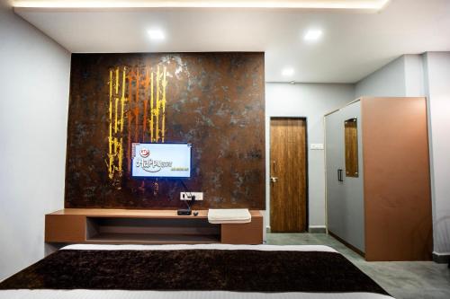 a bathroom with a tv on a wall at Hotel Happy Stay Kolhapur 2 km from kolhapur airport in Kolhapur