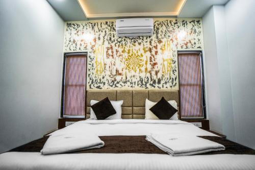 a bedroom with a large bed with a wall at Hotel Happy Stay Kolhapur 2 km from kolhapur airport in Kolhapur