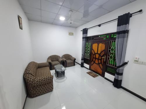 a waiting room with two chairs and a door at Nilaveli Guest House in Nilaveli