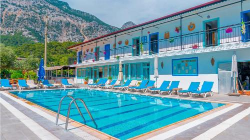 a hotel with a swimming pool with chairs and a building at Get Enjoy Hotels in Beldibi