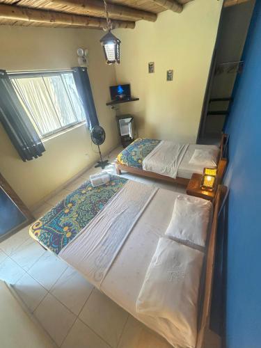 two twin beds in a room with a window at Punta Pacífico Bungalows Máncora in Máncora