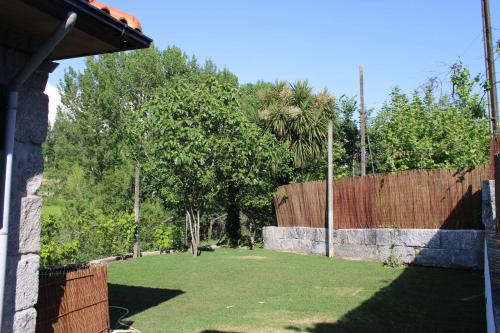 a yard with a retaining wall and a fence at As Casinhas de Santo Ovidio in Fafe