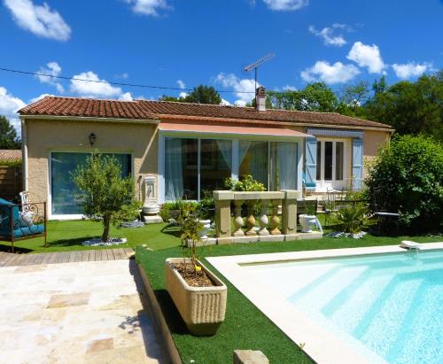 un patio trasero con piscina y una casa en Eclats du Sud, en Auriol