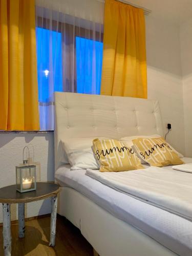 a bed with yellow and blue curtains and a table at Apartman Lana in Jajce