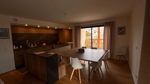 une cuisine avec une table et des chaises dans une pièce dans l'établissement Duplex 140m2 Villard-de-Lans, à Villard-de-Lans