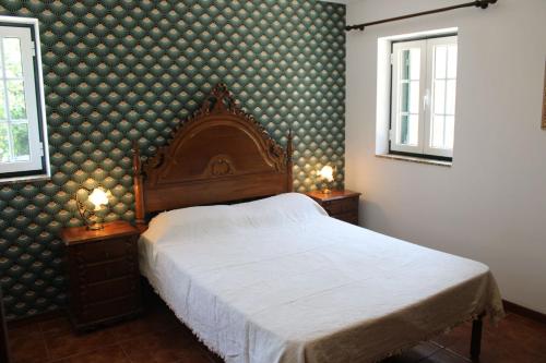 a bedroom with a bed and two night stands with lamps at As Casinhas de Santo Ovidio in Fafe
