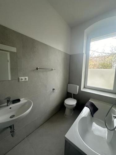 a bathroom with a sink and a toilet and a window at Nice apartment in Berlin3 in Berlin