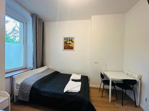 a bedroom with a bed and a table and a window at Nice apartment in Berlin3 in Berlin